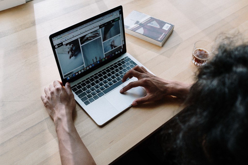 Designer reviewing UI layouts and visual references on a laptop