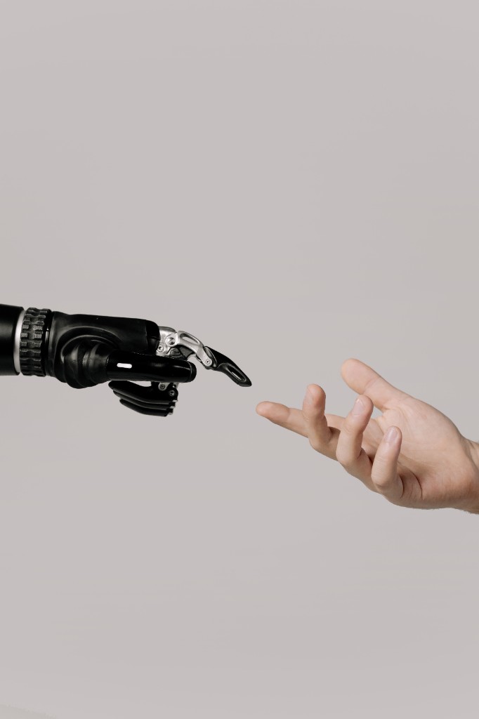 Human hand reaching toward robotic hand